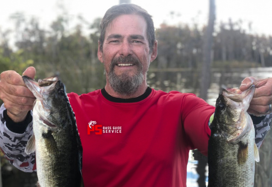 Paul Shenep portrait photo holding 2 bass fish